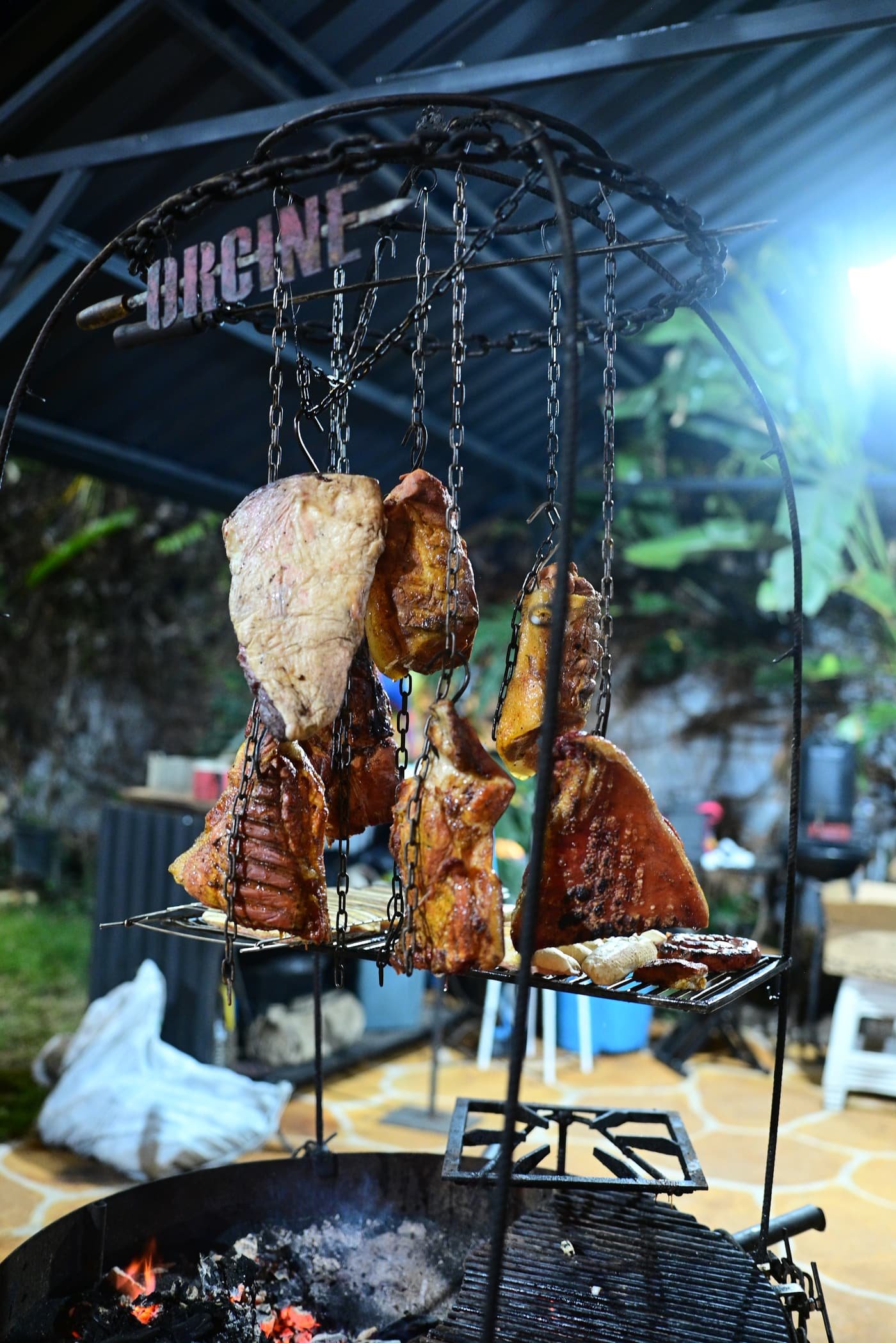 Carnes suspensas no espeto sobre a brasa